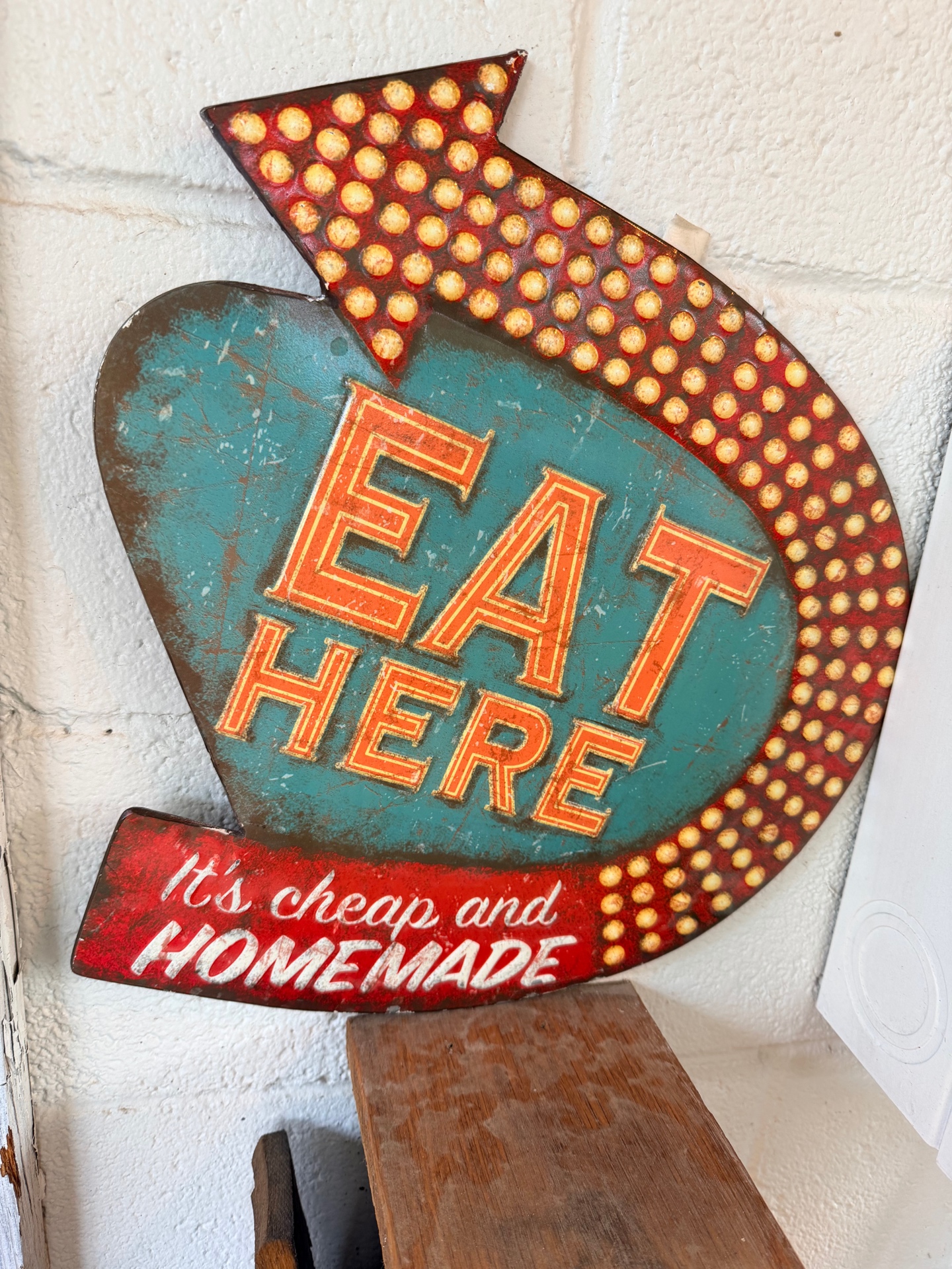 Vintage 'EAT HERE — It's cheap and homemade' sign on brick wall inside The Duck Haus